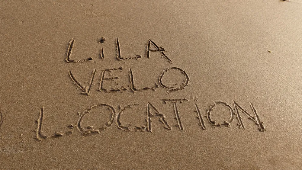 Lila Vélo Location écrit sur le sable de l'Île d'Yeu